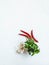 Kitchen flat lay background of red chilli, fresh garlic and bunches of fresh raw herbs in a white mortar. Top view. Copy space