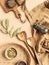 Kitchen flat lay of beige apron, small bowls with spices, metal spice mill, wood kitchen utensils on beige background. Top view.