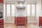 Kitchen furnished in red and white tones in an apartment with large windows.