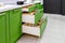 Kitchen furniture in green with open drawers