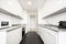 Kitchen with gloss white cabinets on both walls, gray granite