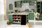 Kitchen with green vintage furniture, pendant lights, marble counter top with flowers and pumpkins, pots of autumn flowers,