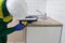 The kitchen installer holds a gun with silicone and smears the end of the countertop to protect it from moisture