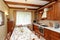 Kitchen interior with wooden furniture and many utensils in warm tones on wide angle view