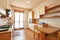 Kitchen interior with wooden table in a sunny day in normal apartment