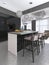 Kitchen island with three bar stools and round glass chandeliers in contemporary black and white kitchen