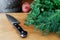 Kitchen knife on wood chopping board next to a large bunch of fr