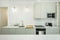 Kitchen with light greenish island, white marble countertop, gold faucet,