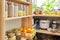 Kitchen pantry, wooden shelves with jars and containers with food, food storage.