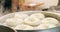 Kitchen, person hands and strainer with bagel in a stove pot with chef, food and bread cooking in restaurant. Cafe, oil