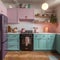 A kitchen with pink and blue cabinets and a black stove. Generative AI image.