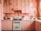 A kitchen with pink cabinets and a white stove. Generative AI image.