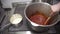 In the kitchen, at the plate two people prepare different sauces.