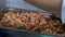 Kitchen of the restaurant, close-up of the chef cuts prawns for salad. Large baking tray, a large number of seafood.