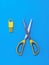 Kitchen scissors for salad and a device for cleaning on a blue background.
