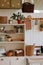 A kitchen with a shelf filled with potted plants and baskets