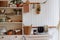 A kitchen with a shelf filled with potted plants and baskets