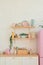 Kitchen shelves, wooden surface and pink fridge on white background. White kitchen interior counter top