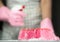 Kitchen sponge in soapy suds on the table. In the background in blur a woman in rubber gloves and with detergent. Close-up.