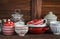 Kitchen still life. Vintage crockery - jar of flour, ceramic bowls, pan, enamelled jar, gravy boat. On a dark brown wooden table