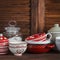 Kitchen still life. Vintage crockery - jar of flour, ceramic bowls, pan, enamelled jar, gravy boat. On a dark brown wooden table