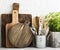 Kitchen still life on a white brick wall background: various cutting boards, tools, greens for cooking, fresh vegetables