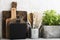 Kitchen still life on a white brick wall background: various cutting boards, tools, greens for cooking, fresh vegetables