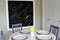Kitchen table, grey chairs and blackboard