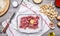 Kitchen table preparation of raw minced meat chopped onion seasoning eggs tomato sauce penne kitchen knife a white napkin on w