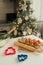 On the kitchen table there is a bowl with flour, a whisk, spices and molds for making Christmas cookies