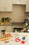 On the kitchen table there is a bowl with flour, a whisk, spices and molds for making Christmas cookies