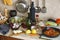 Kitchen utensils, bottles, vegetables and condiments on the kitchen table