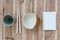 Kitchen utensils and note book on wood background.