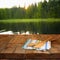 Kitchen utensils on tablecloth on wooden textures table against autumnal forest background