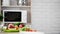 Kitchen view with microwave oven and fresh vegetables and fruit on the table