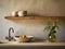 Kitchen water mixer tap on stone counter and wooden shelf with pottery above it