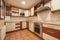 Kitchen with white furniture combined with wood-colored drawers, integrated stainless steel appliances and a similar pink granite