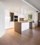 Kitchen with white island with hood and spotlights in modern apartment