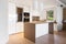 Kitchen with white island with hood and spotlights in modern apartment