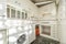 Kitchen with white lacquered wood furniture, stoneware walls, green stoneware floor, butane cylinders for the burners and white