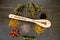 Kitchen Witch - spoon with dried Herbs on gray / grey slate background - chamomile, hibiscus, arnica,  elder flower, rose bud and