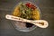 Kitchen Witch - spoon with dried Herbs on gray / grey slate background - chamomile, hibiscus, arnica,  elder flower, rose bud and