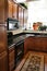 Kitchen wood cabinets black and stainless stove