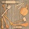 Kitchen wooden utensils spoon, plate, fork, pestle on a table