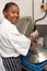 Kitchen Worker Washing Up In Restaurant Kitchen