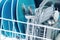 Kitchenware in dishwasher close-up, focus on basket with spoons and forks
