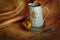 Kitchenware for villagers. Nutrmort with jugs, an apple and a knife. Warm fabric background. Autumn tones. Rustic style