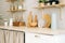 Kitchenware on the wooden table in modern bright kitchen