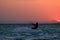 Kite boarder sportsman under sunset sun, freestyle kiteboarding rider on the evening kitesession, sunset in the sea, extreme