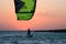 Kite boarder sportsman under sunset sun, freestyle kiteboarding rider on the evening kitesession, sunset in the sea, extreme